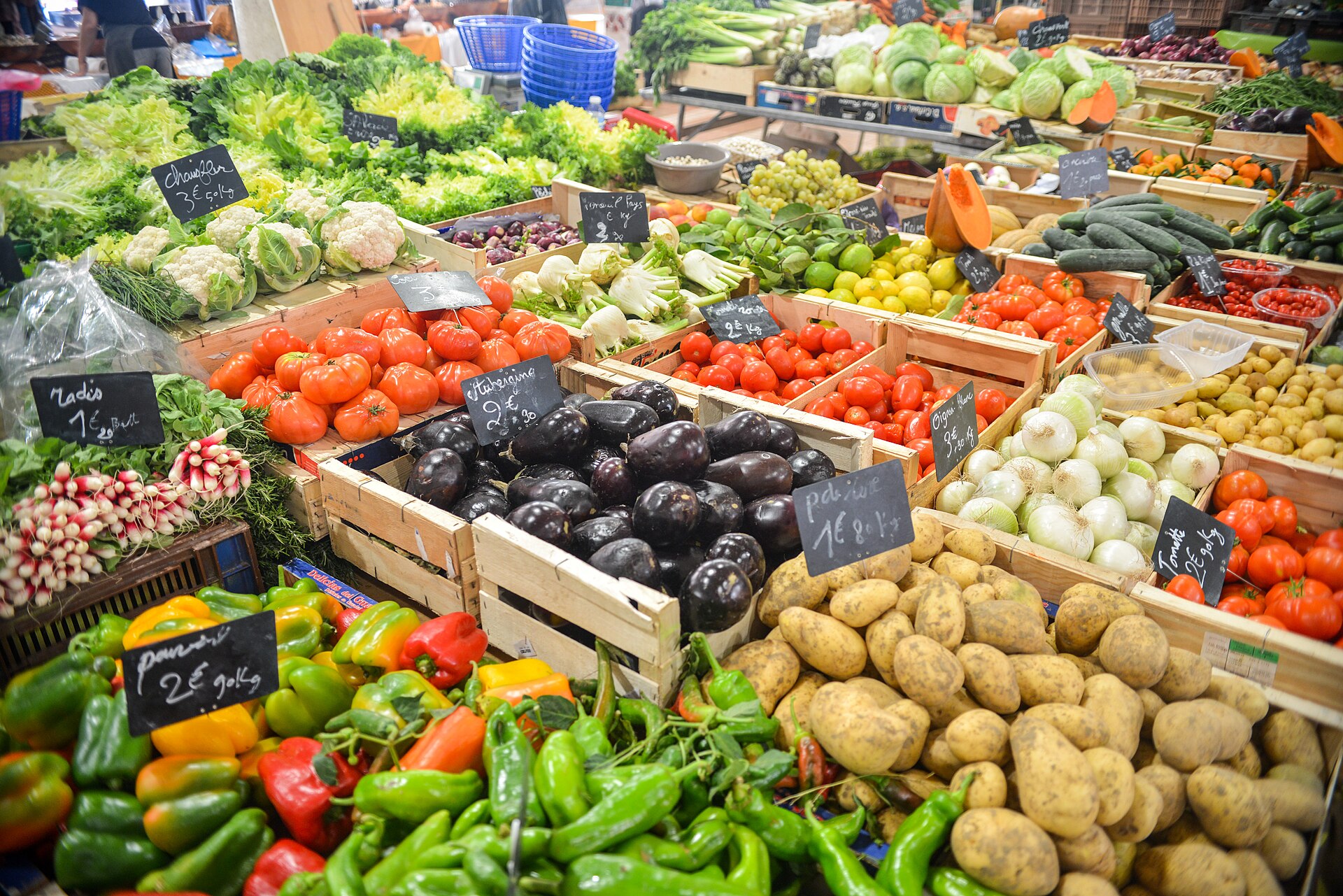 An assortment of fresh vegetables and potatoes on a wooden surface.